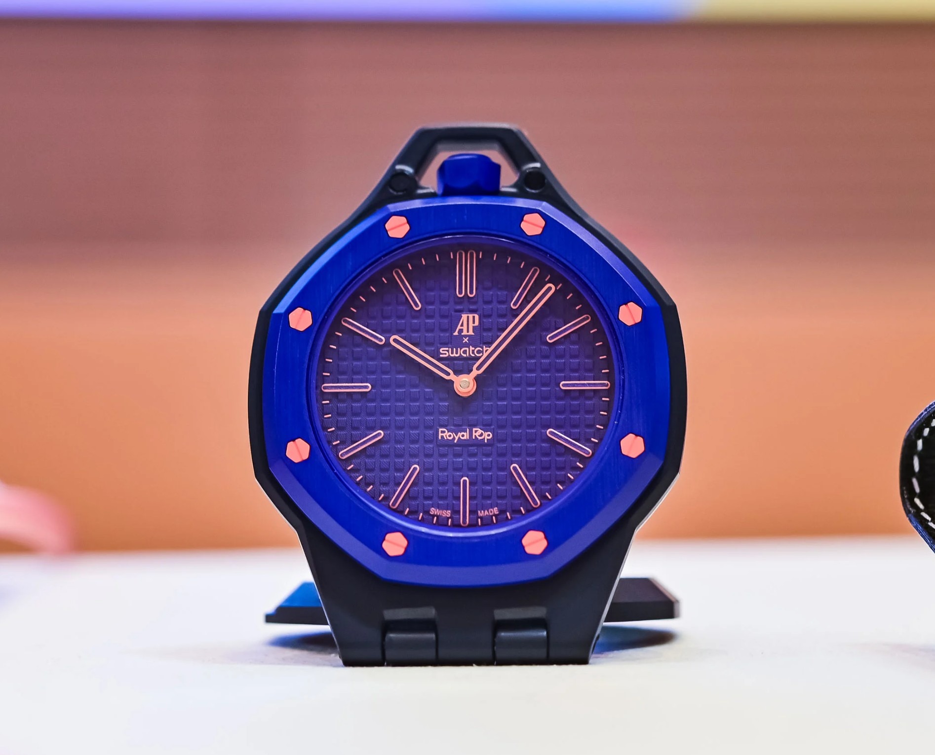 El Audemars Piguet x Swatch Collection Bioceramic Royal Pop Orenji Hachi, como reloj de mesa